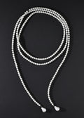 White beaded necklace on a black background