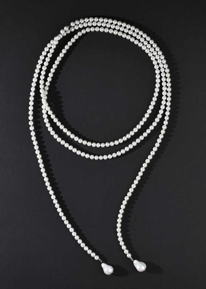 White beaded necklace on a black background