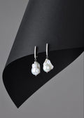 Pearl earrings on a black and gray background