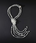 Pearl necklace with a knot on a black background