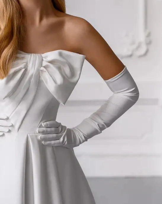 White off-shoulder dress with long gloves on a plain background