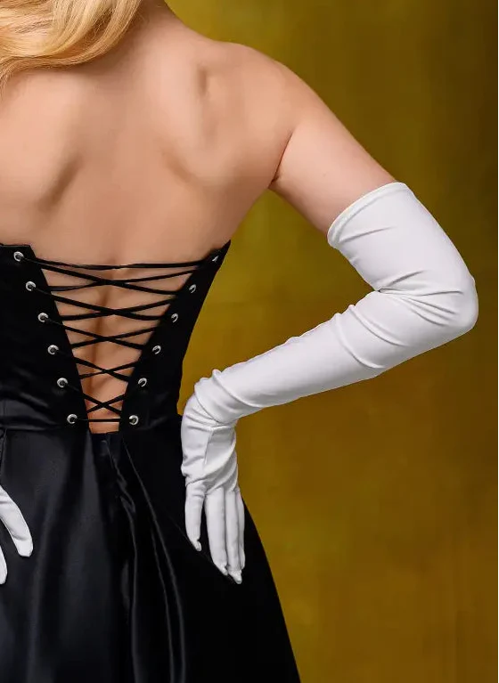Black dress with lace-up back and white gloves on a yellow background