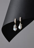 Pearl earrings with gold accents on a black and gray background